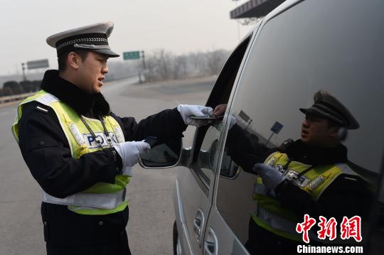 1月29日,零下8摄氏度,山西“东大门”——长邯高速公路长治市黎城县东阳关站,在这条被称为山西“死亡路段”的高速路段,记者目睹高速交警在严寒中护航春运。图为交警检查路过车辆安全。 武俊杰 摄 1月29日,零下8摄氏度,山西“东大门”——长邯高速公路长治市黎城县东阳关站,在这条被称为山西“死亡路段”的高速路段,记者目睹高速交警在严寒中护航春运。图为交警检查路过车辆安全。 武俊杰 摄