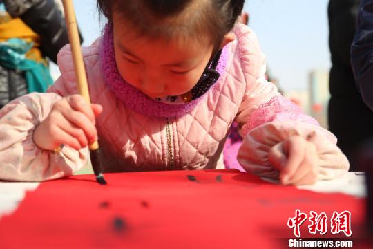 图为正在书写春联的小小“书法家”。 张海雯 摄 图为正在书写春联的小小“书法家”。 张海雯 摄