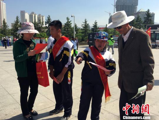 图为学生志愿者给市民们讲环保。 孙睿 摄 图为学生志愿者给市民们讲环保。 孙睿 摄