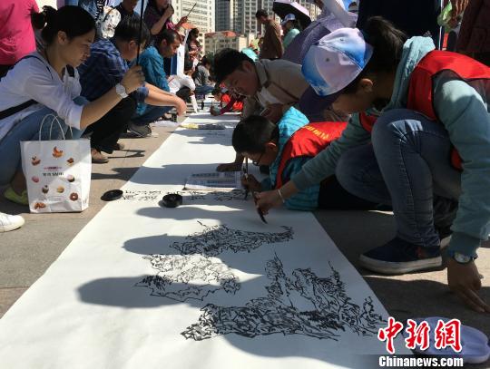 图为小学生志愿者们用自己手中的画笔,在百米长卷上画出“我爱家乡水”。 孙睿 摄 图为小学生志愿者们用自己手中的画笔,在百米长卷上画出“我爱家乡水”。 孙睿 摄