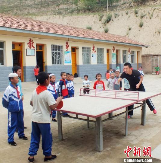 图为课间十分钟,于瑞和学生们一起打乒乓球。 郭红 摄 图为课间十分钟,于瑞和学生们一起打乒乓球。 郭红 摄