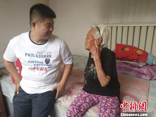 百岁老人马小金和村主任进行交流。 王天译 摄 百岁老人马小金和村主任进行交流。 王天译 摄